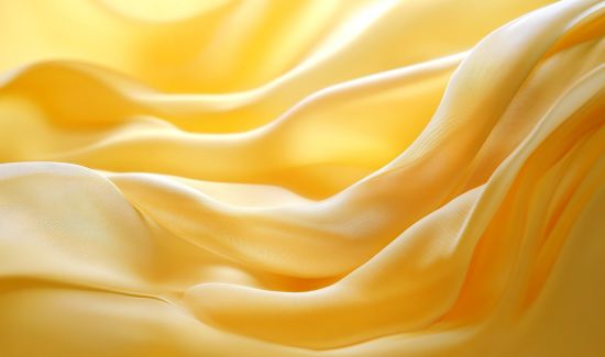 Flowing yellow silk fabric with soft folds and texture